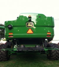 green tractor with a slow moving vehicle sign 